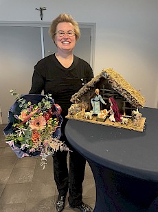 Sandra met een uniek afscheidscadeau: Kerststal met beeldjes van was, handgemaakt door de zusters uit Turnhout en natuurlijk een bosje bloemen